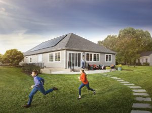 Kids running in front of house with solar panels